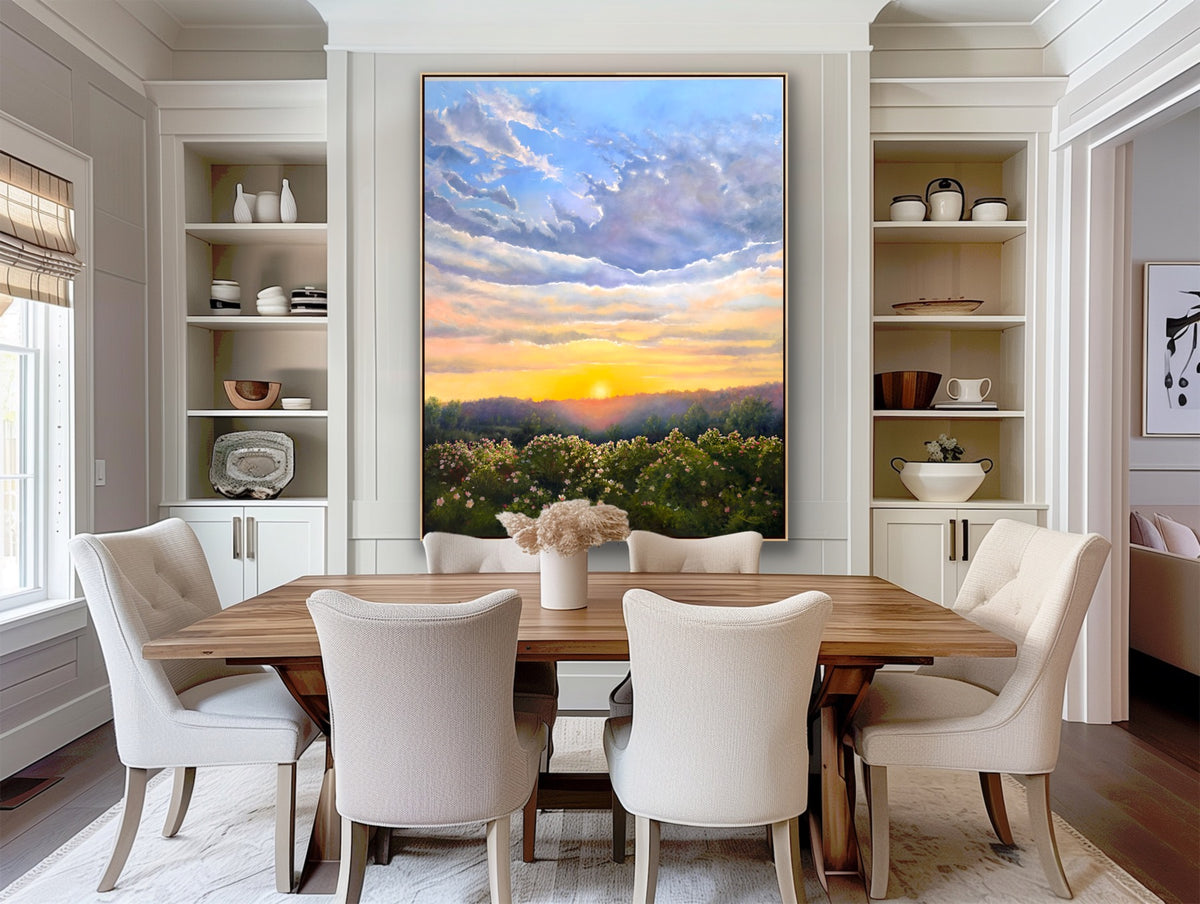Dining room with a large painting of a sunset over a landscape on the wall.